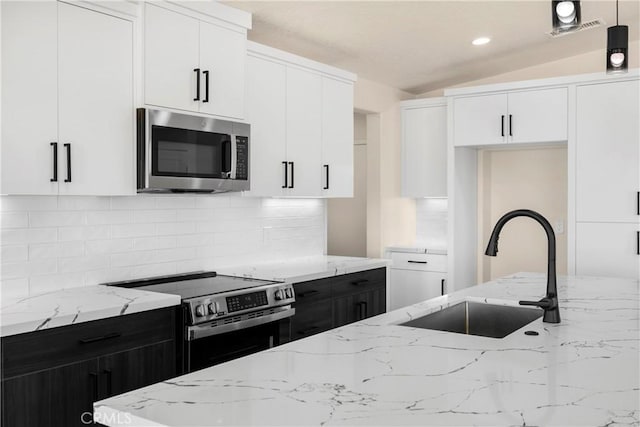 9641 Buena Vista St, Apple Valley, CA 92308 - kitchen with stainless steel appliances, a sink, tasteful backsplash, vaulted ceiling, and white cabinets