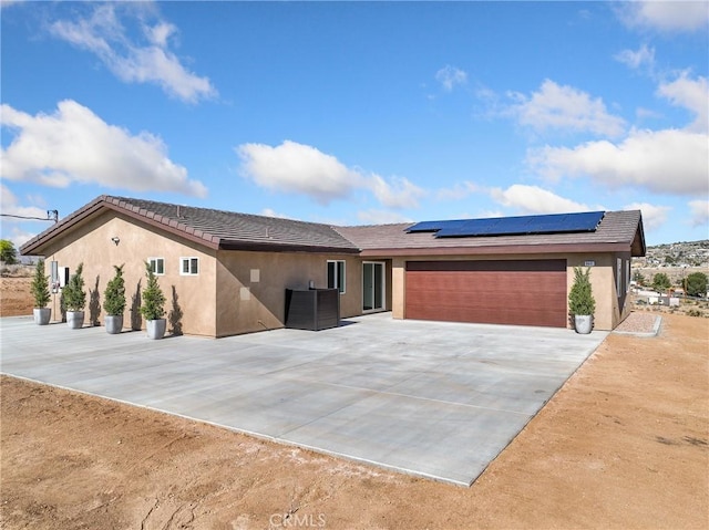 9641 Buena Vista St, Apple Valley, CA 92308 - ranch-style house with stucco siding, roof mounted solar panels, driveway, and an attached garage