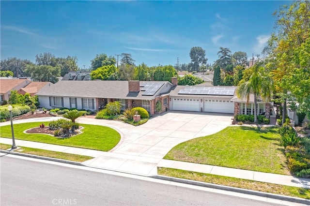 3152 Parkside Dr, San Bernardino, CA 92404 - ranch-style home with an attached garage, concrete driveway, roof mounted solar panels, and a front yard