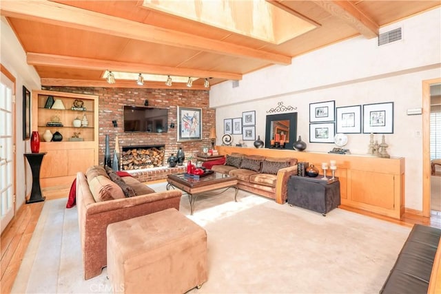 3152 Parkside Dr, San Bernardino, CA 92404 - living room with hardwood / wood-style floors, rail lighting, wood ceiling with exposed beams, and a brick fireplace