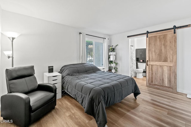 205 W Channel Islands Blvd, Port Hueneme, CA 93041 - bedroom with a barn door, light wood-type flooring, and ensuite bathroom