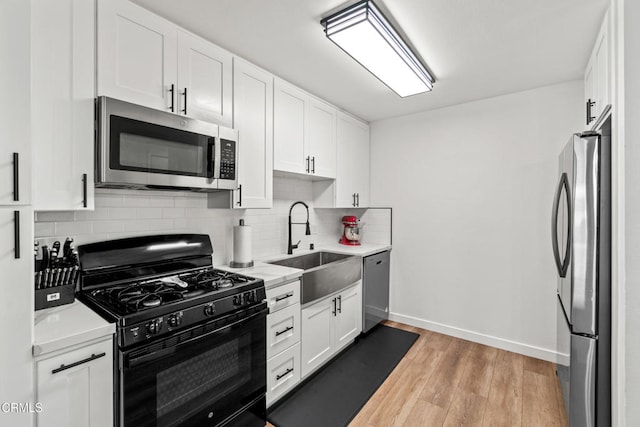 205 W Channel Islands Blvd, Port Hueneme, CA 93041 - kitchen with stainless steel appliances, a sink, light countertops, backsplash, and white cabinets