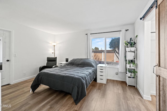 205 W Channel Islands Blvd, Port Hueneme, CA 93041 - bedroom with a barn door, light wood-type flooring, and baseboards