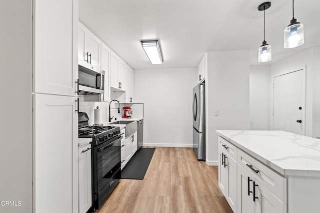 205 W Channel Islands Blvd, Port Hueneme, CA 93041 - kitchen with appliances with stainless steel finishes, light wood-style floors, a sink, white cabinetry, and baseboards