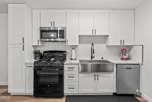 205 W Channel Islands Blvd, Port Hueneme, CA 93041 - kitchen with appliances with stainless steel finishes, a sink, white cabinetry, and backsplash