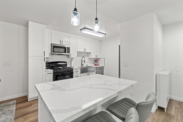205 W Channel Islands Blvd, Port Hueneme, CA 93041 - kitchen featuring appliances with stainless steel finishes, baseboards, a sink, and white cabinetry
