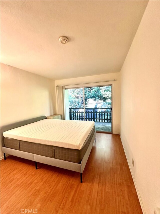 2 Panoramic Way Unit 302, Berkeley, CA 94704 - bedroom with access to exterior, wood finished floors, and baseboards