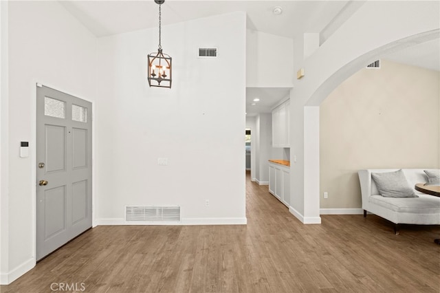 27054 Riversbridge Way, Valencia, CA 91354 - entrance foyer featuring a towering ceiling, arched walkways, light wood-type flooring, and a chandelier