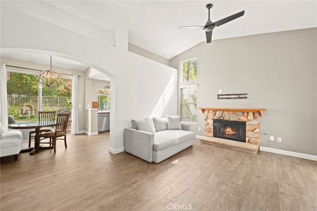 27054 Riversbridge Way, Valencia, CA 91354 - living area with wood finished floors, a ceiling fan, a stone fireplace, a chandelier, and arched walkways