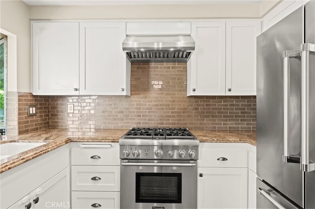 27054 Riversbridge Way, Valencia, CA 91354 - kitchen with high end appliances, wall chimney range hood, white cabinets, tasteful backsplash, and light stone counters