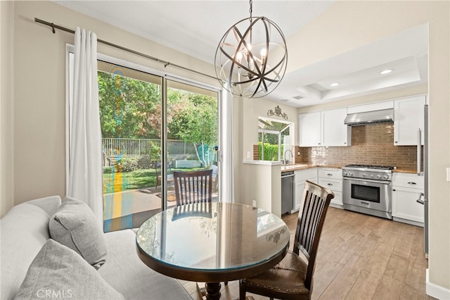27054 Riversbridge Way, Valencia, CA 91354 - dining space with healthy amount of natural light, a chandelier, light wood-type flooring, recessed lighting, and a raised ceiling