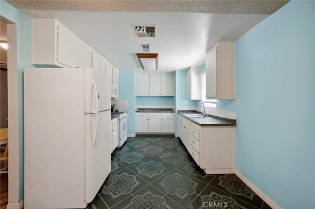41125 179th St E, Lancaster, CA 93535 - kitchen featuring white appliances, dark countertops, a sink, and white cabinetry