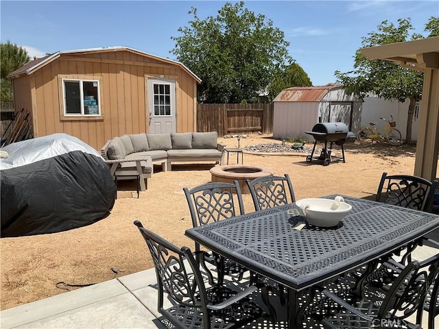 17911 Juniper St, Adelanto, CA 92301 - fenced backyard with a grill, outdoor dining area, a patio area, and an outdoor living space with a fire pit