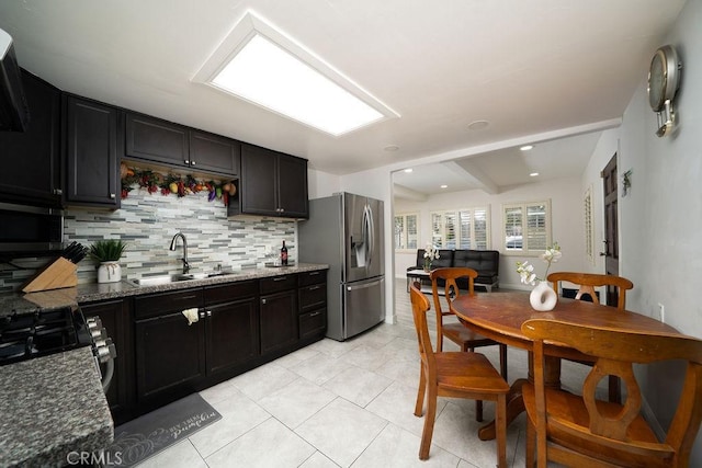 3603 W 144th Pl, Hawthorne, CA 90250 - kitchen featuring stainless steel refrigerator with ice dispenser, a sink, backsplash, dark stone counters, and light tile patterned flooring
