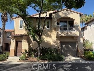 39244 Turtle Bay Ln Unit F, Murrieta, CA 92563 - mediterranean / spanish-style home with a balcony, stucco siding, and an attached garage