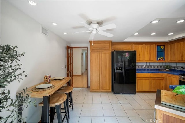 29111 Pompano Way, Laguna Niguel, CA 92677 - kitchen with black fridge with ice dispenser, a ceiling fan, glass insert cabinets, recessed lighting, and tasteful backsplash