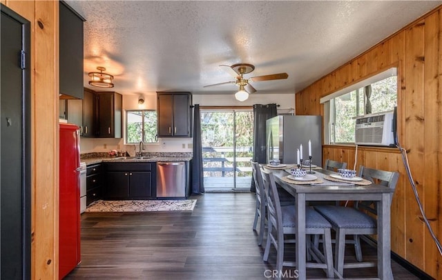 29148 Lyon Dr, Cedar Glen, CA 92321 - kitchen with appliances with stainless steel finishes, wood walls, ceiling fan, dark wood-style floors, and a sink