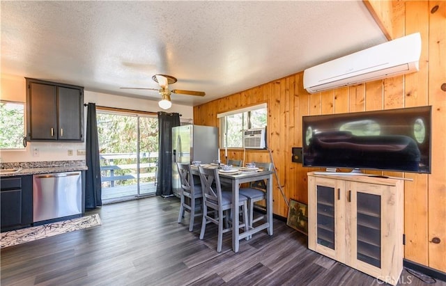 29148 Lyon Dr, Cedar Glen, CA 92321 - kitchen with stainless steel dishwasher, a wall mounted air conditioner, a textured ceiling, wooden walls, and ceiling fan