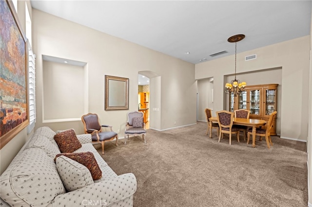 41799 Cascades Ct, Temecula, CA 92591 - carpeted living room featuring a chandelier, arched walkways, and baseboards