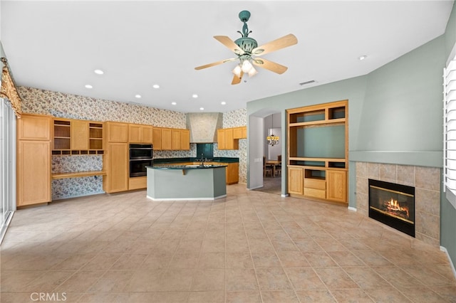 41799 Cascades Ct, Temecula, CA 92591 - kitchen featuring dark countertops, a tile fireplace, ceiling fan, a kitchen island, and open shelves