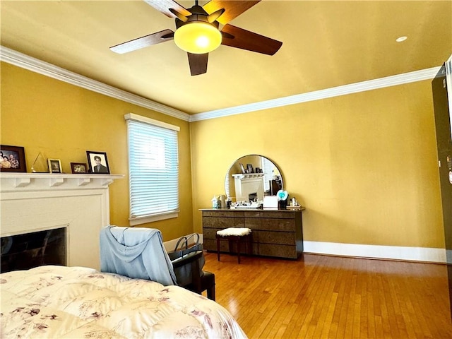 867 S Bronson Ave, Los Angeles, CA 90005 - bedroom featuring hardwood / wood-style floors, ornamental molding, baseboards, a ceiling fan, and a glass covered fireplace