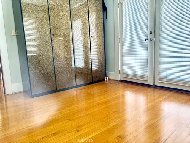 867 S Bronson Ave, Los Angeles, CA 90005 - unfurnished bedroom with wood finished floors and baseboards