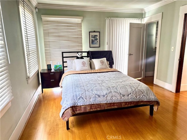 867 S Bronson Ave, Los Angeles, CA 90005 - bedroom featuring hardwood / wood-style flooring, baseboards, ornamental molding, and multiple windows