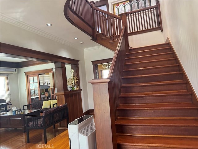 867 S Bronson Ave, Los Angeles, CA 90005 - staircase featuring ornamental molding, a wall mounted AC, wood finished floors, and recessed lighting