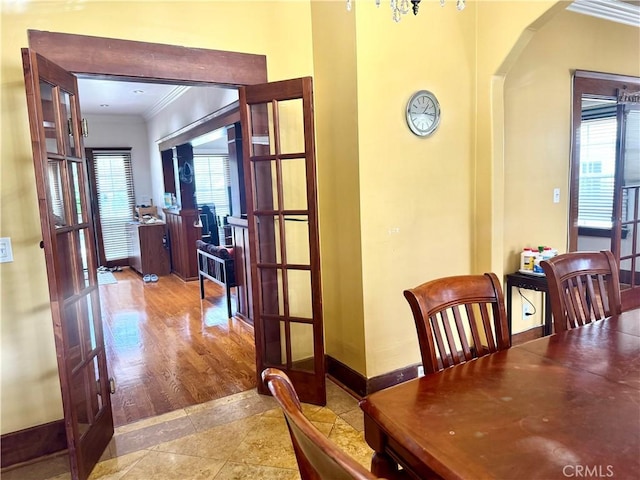 867 S Bronson Ave, Los Angeles, CA 90005 - tiled dining room featuring ornamental molding, healthy amount of natural light, french doors, arched walkways, and baseboards