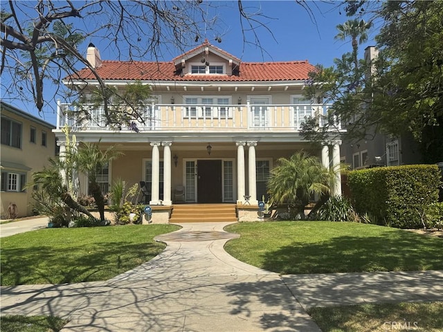 867 S Bronson Ave, Los Angeles, CA 90005 - mediterranean / spanish-style home with a balcony, a porch, stucco siding, a tiled roof, and a chimney