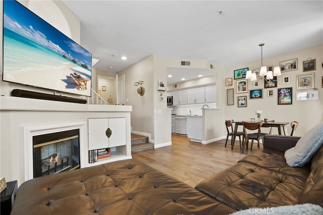 2348 Sunningdale Dr, Tustin, CA 92782 - living area with a chandelier, wood finished floors, stairway, a glass covered fireplace, and recessed lighting