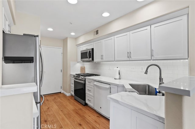 2348 Sunningdale Dr, Tustin, CA 92782 - kitchen featuring stainless steel appliances, a sink, tasteful backsplash, light wood-style floors, and light stone counters