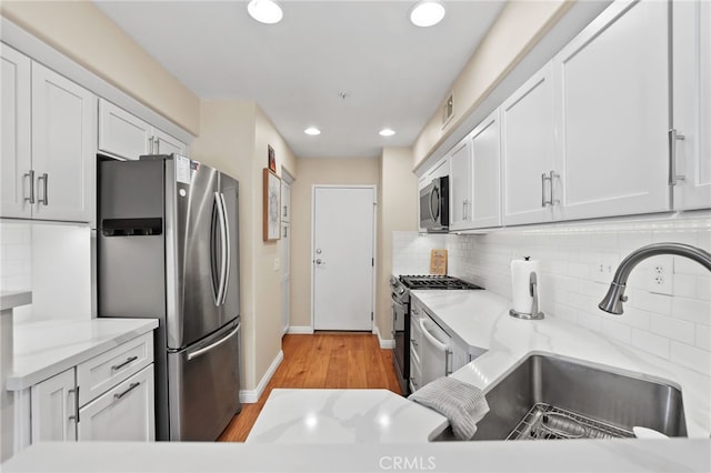 2348 Sunningdale Dr, Tustin, CA 92782 - kitchen featuring appliances with stainless steel finishes, a sink, decorative backsplash, white cabinets, and recessed lighting