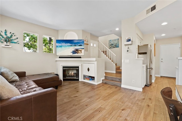 2348 Sunningdale Dr, Tustin, CA 92782 - living area with light wood-style flooring, a glass covered fireplace, stairway, and recessed lighting