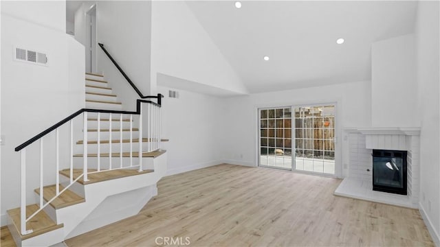 7059 Potenza Pl, Rancho Cucamonga, CA 91701 - unfurnished living room featuring wood finished floors, high vaulted ceiling, stairs, recessed lighting, and a fireplace