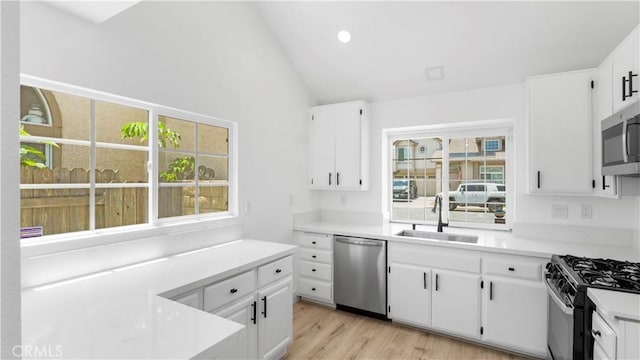 7059 Potenza Pl, Rancho Cucamonga, CA 91701 - kitchen featuring appliances with stainless steel finishes, a sink, light countertops, light wood finished floors, and high vaulted ceiling