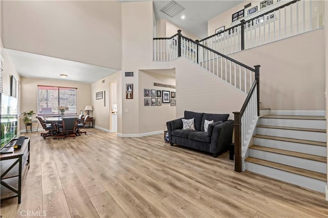 28436 Calex Dr, Valencia, CA 91354 - living area with wood finished floors, stairway, a towering ceiling, and baseboards