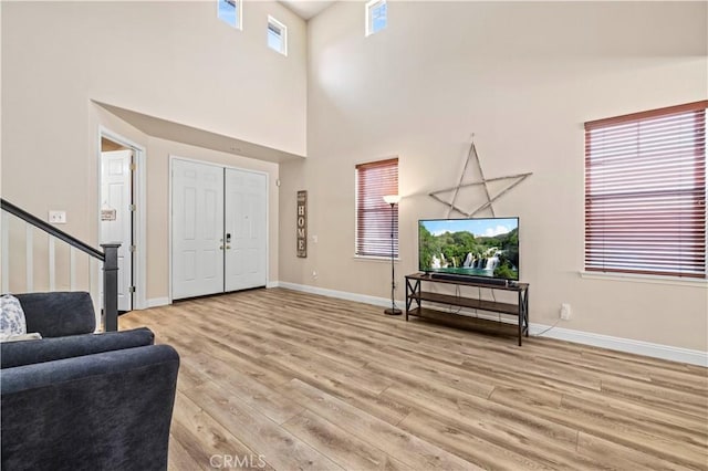28436 Calex Dr, Valencia, CA 91354 - foyer entrance with light wood-style floors, a towering ceiling, baseboards, and stairs