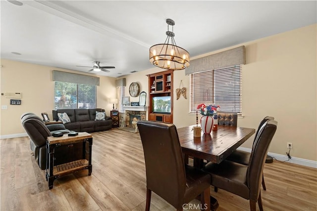 28436 Calex Dr, Valencia, CA 91354 - dining space featuring light wood finished floors, ceiling fan, a chandelier, baseboards, and a fireplace