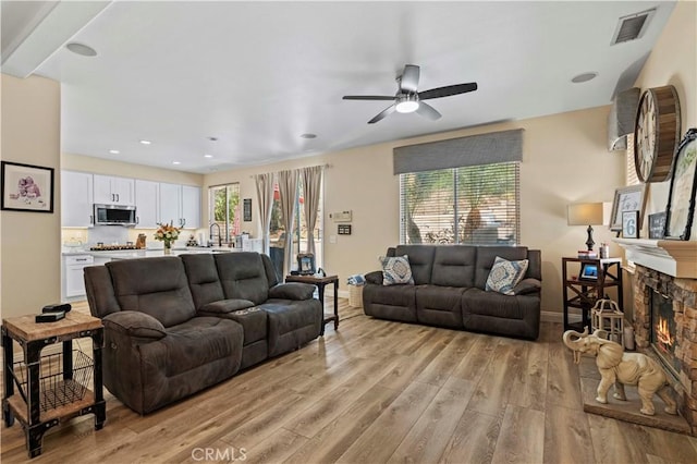 28436 Calex Dr, Valencia, CA 91354 - living area featuring light wood-style floors, a ceiling fan, a fireplace, and baseboards