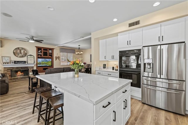28436 Calex Dr, Valencia, CA 91354 - kitchen featuring stainless steel fridge, open floor plan, a kitchen island, ceiling fan, and white cabinets