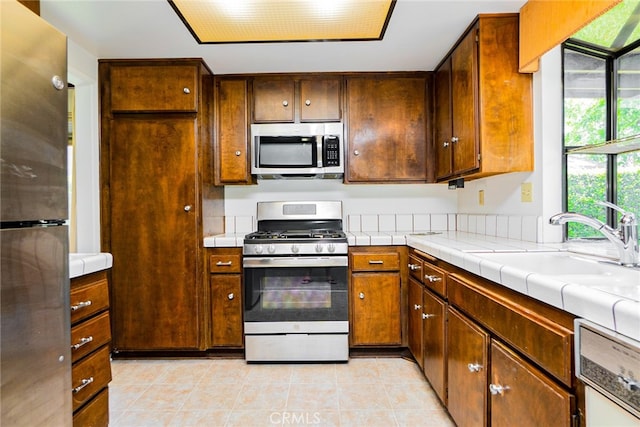 751 Santa Fe Ct, San Dimas, CA 91773 - kitchen featuring appliances with stainless steel finishes, light tile patterned flooring, tile countertops, and a sink