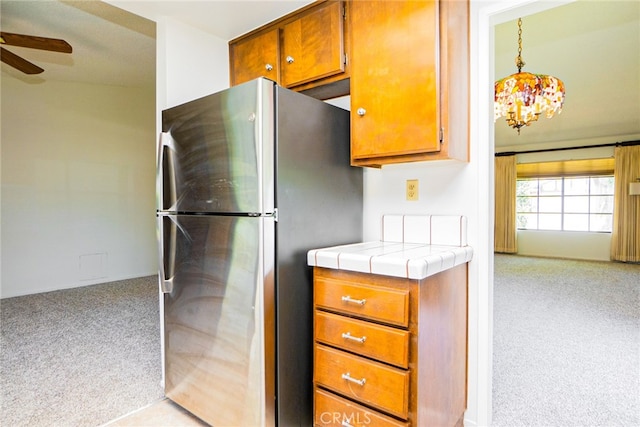 751 Santa Fe Ct, San Dimas, CA 91773 - kitchen featuring freestanding refrigerator, light carpet, a ceiling fan, tile counters, and brown cabinetry