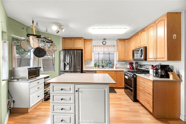 1784 Promenade Pl, Vista, CA 92083 - kitchen featuring stainless steel appliances, light wood-style flooring, light countertops, a sink, and a textured ceiling