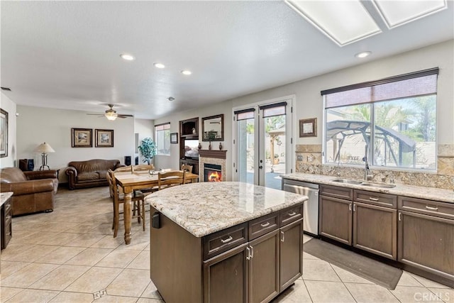 3582 Cedar Ridge Ln, Corona, CA 92881 - kitchen featuring a sink, dishwasher, light tile patterned flooring, a lit fireplace, and recessed lighting