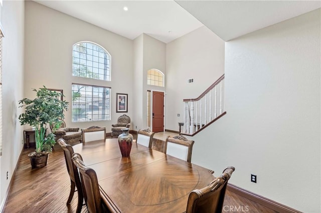 3582 Cedar Ridge Ln, Corona, CA 92881 - dining area with wood finished floors, stairs, a high ceiling, and baseboards