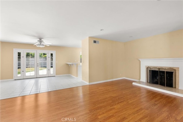 20632 Egret Ln, Huntington Beach, CA 92646 - unfurnished living room featuring wood finished floors, a ceiling fan, french doors, and a fireplace with raised hearth