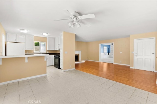 20632 Egret Ln, Huntington Beach, CA 92646 - kitchen featuring fridge, range, open floor plan, a ceiling fan, and white cabinetry