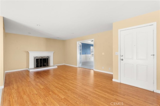 20632 Egret Ln, Huntington Beach, CA 92646 - unfurnished living room featuring light wood-style floors, a fireplace with raised hearth, and baseboards
