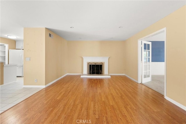 20632 Egret Ln, Huntington Beach, CA 92646 - unfurnished living room with light wood finished floors, baseboards, and a fireplace with raised hearth
